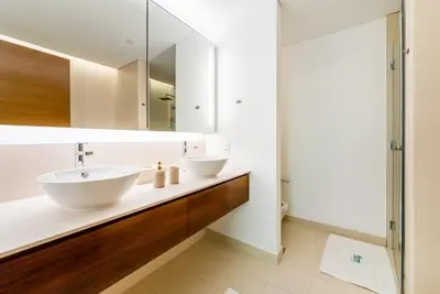 a bathroom with two sinks and a mirror at Elegant 3BR with Maids Room City Walk Dubai in Dubai