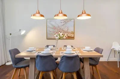 a dining room with a table with chairs and a painting at Stylish 2BR with Maids Room City Walk in Dubai