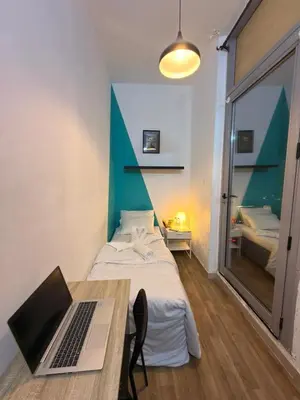 a bedroom with a bed and a laptop on a table at Budget Stay Dubai Tecom Barsha Heights in Dubai