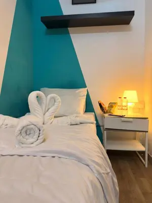 a bedroom with a bed with towels on it at Budget Stay Dubai Tecom Barsha Heights in Dubai
