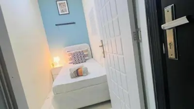 a small room with a bed and a white door at Budget Stay Dubai Tecom Barsha Heights in Dubai