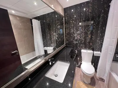 a black and white bathroom with a toilet and a tub at Elite Residence 1, Downtown Dubai in Dubai