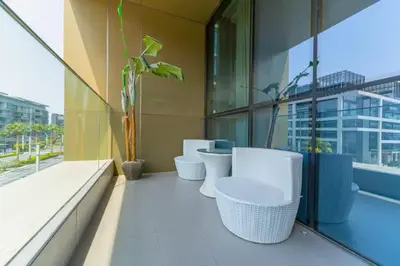 a balcony with white chairs and plants on a building at Spacious 2BR with Maids Room City Walk in Dubai