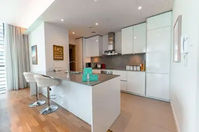 a kitchen with white cabinets and a counter top at Spacious 2BR with Maids Room City Walk in Dubai