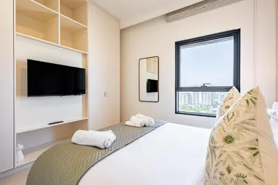 a bedroom with a large bed with a flat screen tv at Superhost - 1BR Apartment, Balcony, Pool & Gym , Dubai Hills in Dubai