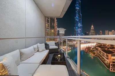 a balcony with a view of a city at night at Large 4 Bed Apt with Burj View and 8 Min Walk to Mall by Vista Stays DXB in Dubai