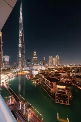 a view of a city at night with a river at Large 4 Bed Apt with Burj View and 8 Min Walk to Mall by Vista Stays DXB in Dubai