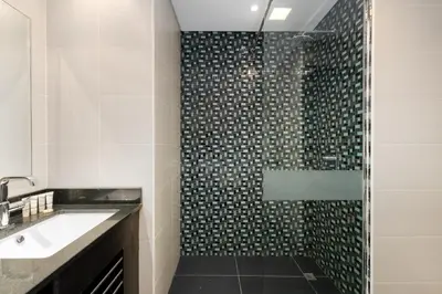 a bathroom with a shower and a sink at Cayan Tower, Dubai Marina - Onelink in Dubai