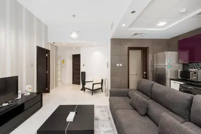 a living room with a couch and a kitchen at Cayan Tower, Dubai Marina - Onelink in Dubai