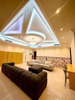 a living room with a large couch and a ceiling at Risephoenix Japanese Luxury Capsule Villa - Dubai in Dubai