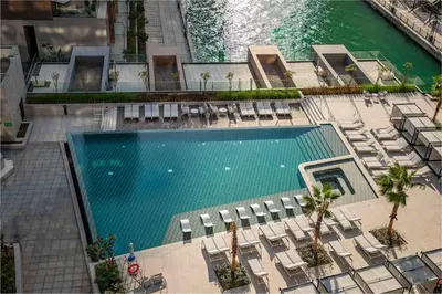 an overhead view of a swimming pool with chairs and water at Frank Porter - Peninsula One in Dubai
