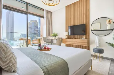 a hotel room with a bed and a television at Frank Porter - Peninsula One in Dubai