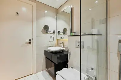 a bathroom with a sink and a glass shower at Majesty Stay 2BR in Dubai
