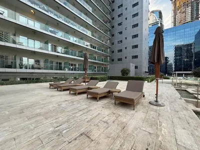 a row of chairs and umbrellas in front of a building at Majesty Stay 2BR in Dubai