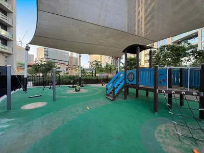 a playground with swings and a play equipment at The Iconic Stay 2BR in Dubai