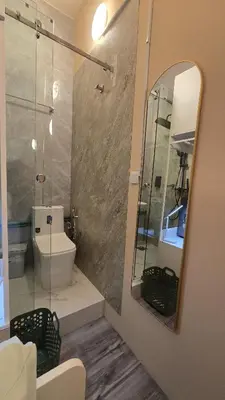 a bathroom with a toilet and a mirror at Partition with attached washroom in Dubai