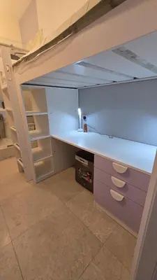 a loft bed with a desk in a room at Partition with attached washroom in Dubai