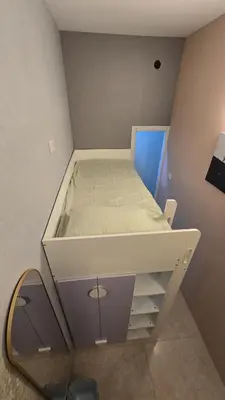 a large white bed in a room with a mirror at Partition with attached washroom in Dubai