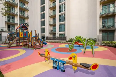 a playground in front of a large building at Family Friendly Studio in Dubai City Views Pool Free Parking in Dubai