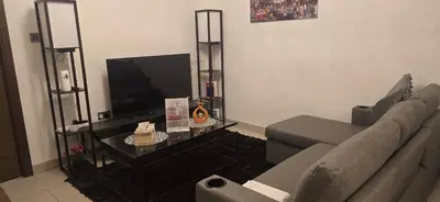 a living room with a couch and a tv at Family Friendly Studio in Dubai City Views Pool Free Parking in Dubai