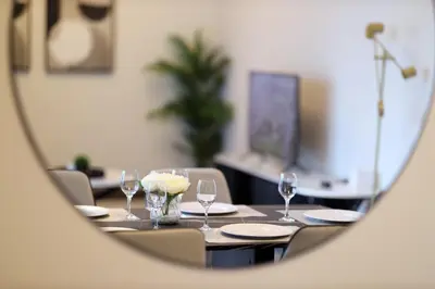 a table with glasses and plates on it in a mirror at Velvet Rose with Burj and canal view 2Bedrooms in Solbay in Dubai