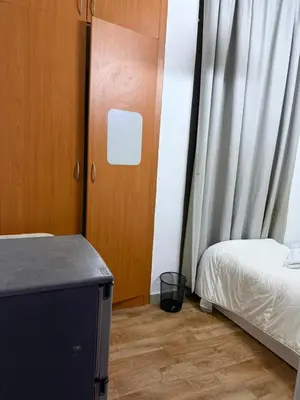 a room with two beds and a door and a table at Peaceful Budget Stay Dubai In Tecom Near Metro in Dubai