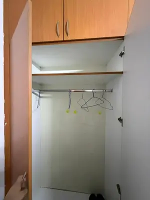 a person is reaching for a hook in a closet at Peaceful Budget Stay Dubai In Tecom Near Metro in Dubai