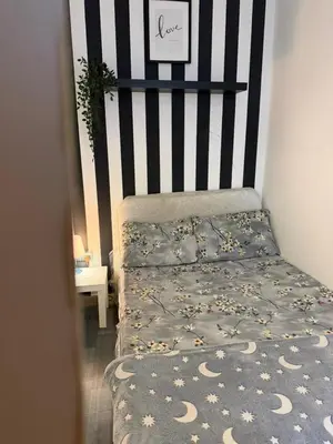 a bedroom with a bed with a black and white stripes at Royal Budget Stay Dubai In Tecom Near Metro in Dubai
