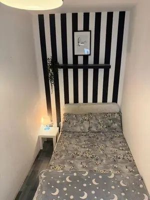 a bedroom with a bed with a black and white striped wall at Royal Budget Stay Dubai In Tecom Near Metro in Dubai