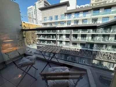 a balcony with a bench and chairs on a building at Refined Urban Studio Walk to Circle Mall in Dubai