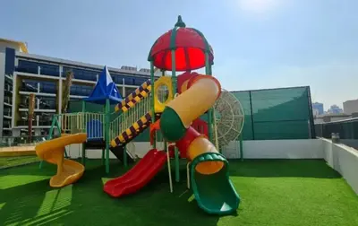 a playground with a slide on a roof at Refined Urban Studio Walk to Circle Mall in Dubai