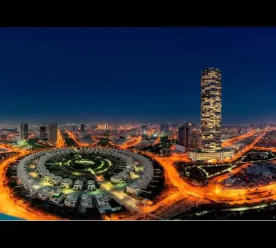 a night view of a city with a tall building at Refined Urban Studio Walk to Circle Mall in Dubai