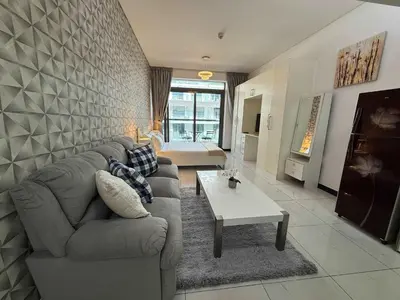 a living room with a couch and a table at Refined Urban Studio Walk to Circle Mall in Dubai