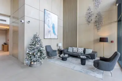 a living room with a christmas tree and chairs at STAY BY LATINEM Luxury 1BR Holiday Home W-407 near Burj-Khalifa in Dubai