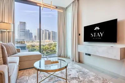 a living room with a couch and a tv at STAY BY LATINEM Luxury 1BR Holiday Home W-407 near Burj-Khalifa in Dubai