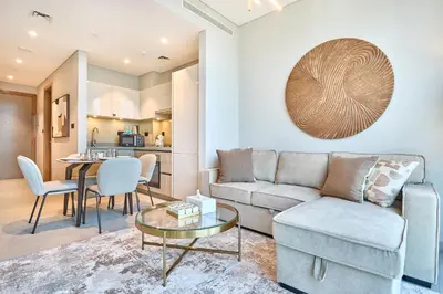 a living room with a couch and a table at STAY BY LATINEM Luxury 1BR Holiday Home W-407 near Burj-Khalifa in Dubai