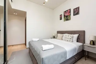 a bedroom with a large bed with white sheets at Elegant 2BR Apartment in Binghatti Heights in Dubai