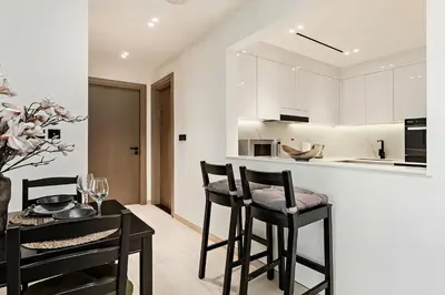 a kitchen with black chairs and a table and a counter at Elegant 2BR Apartment in Binghatti Heights in Dubai