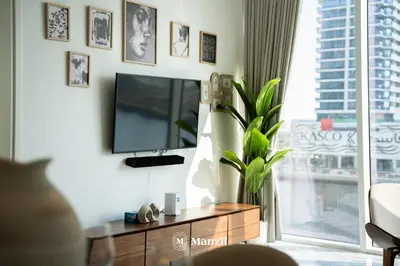 a living room with a tv and a large window at Modern 1BR with Stunning Lake View in Business Bay in Dubai