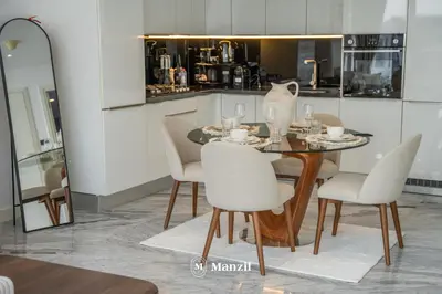a dining room with a table and white chairs at Modern 1BR with Stunning Lake View in Business Bay in Dubai