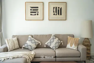 a living room with a couch and two pictures on the wall at Modern 1BR with Stunning Lake View in Business Bay in Dubai