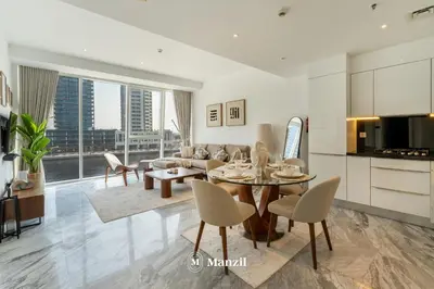 a kitchen and living room with a table and chairs at Modern 1BR with Stunning Lake View in Business Bay in Dubai