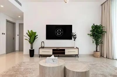 a living room with a tv on a white wall at Beachfront 1BR Retreat Beach Isle Tower 01 in Dubai