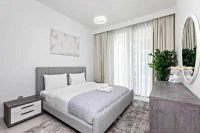 a bedroom with a bed and a large window at Beachfront 1BR Retreat Beach Isle Tower 01 in Dubai