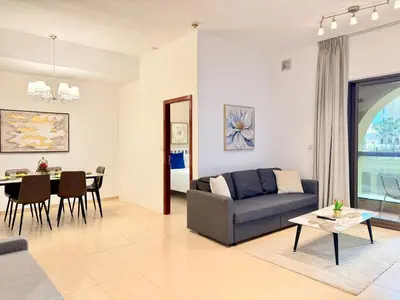 a living room with a couch and a table at Brand-New 4BR on JBR Beach Near metro, mall By Sunkissed Holiday Homes in Dubai