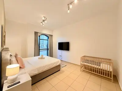 a large bedroom with a bed and a tv at Brand-New 4BR on JBR Beach Near metro, mall By Sunkissed Holiday Homes in Dubai