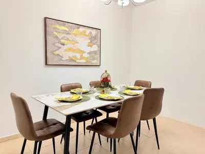 a dining room table with chairs and a painting at Brand-New 4BR on JBR Beach Near metro, mall By Sunkissed Holiday Homes in Dubai