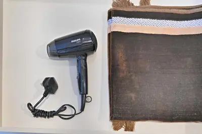 a blow dryer is next to a book at Bloomfields STU in Business Bay, Bayz by Danube in Dubai