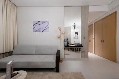 a living room with a couch and a dining room at Stylish 2BR Connected to Dubai Mall with Full Burj Khalifa View in Dubai