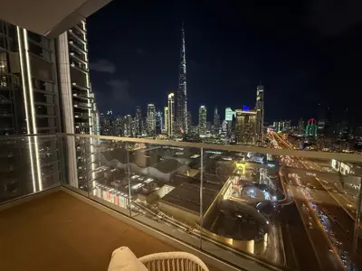 a view of a city skyline at night from a balcony at Stylish 2BR Connected to Dubai Mall with Full Burj Khalifa View in Dubai